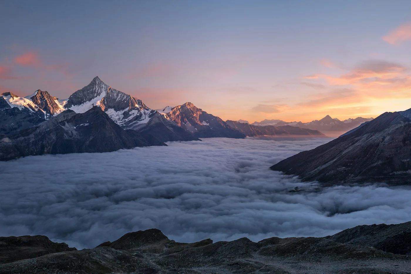 Swiss Alps at sunset above the clouds